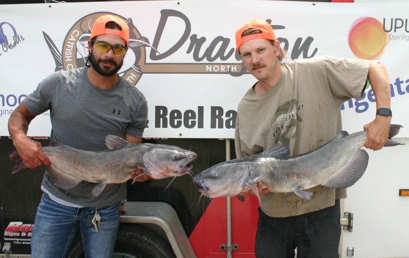 Picture of man and woman as catfish dtournament winners holding catfish catch
